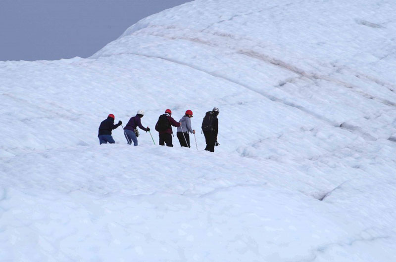 Vorsicht geboten: Mit unsicheren Schritten gehen die Touristen über das Eis des Gletschers.