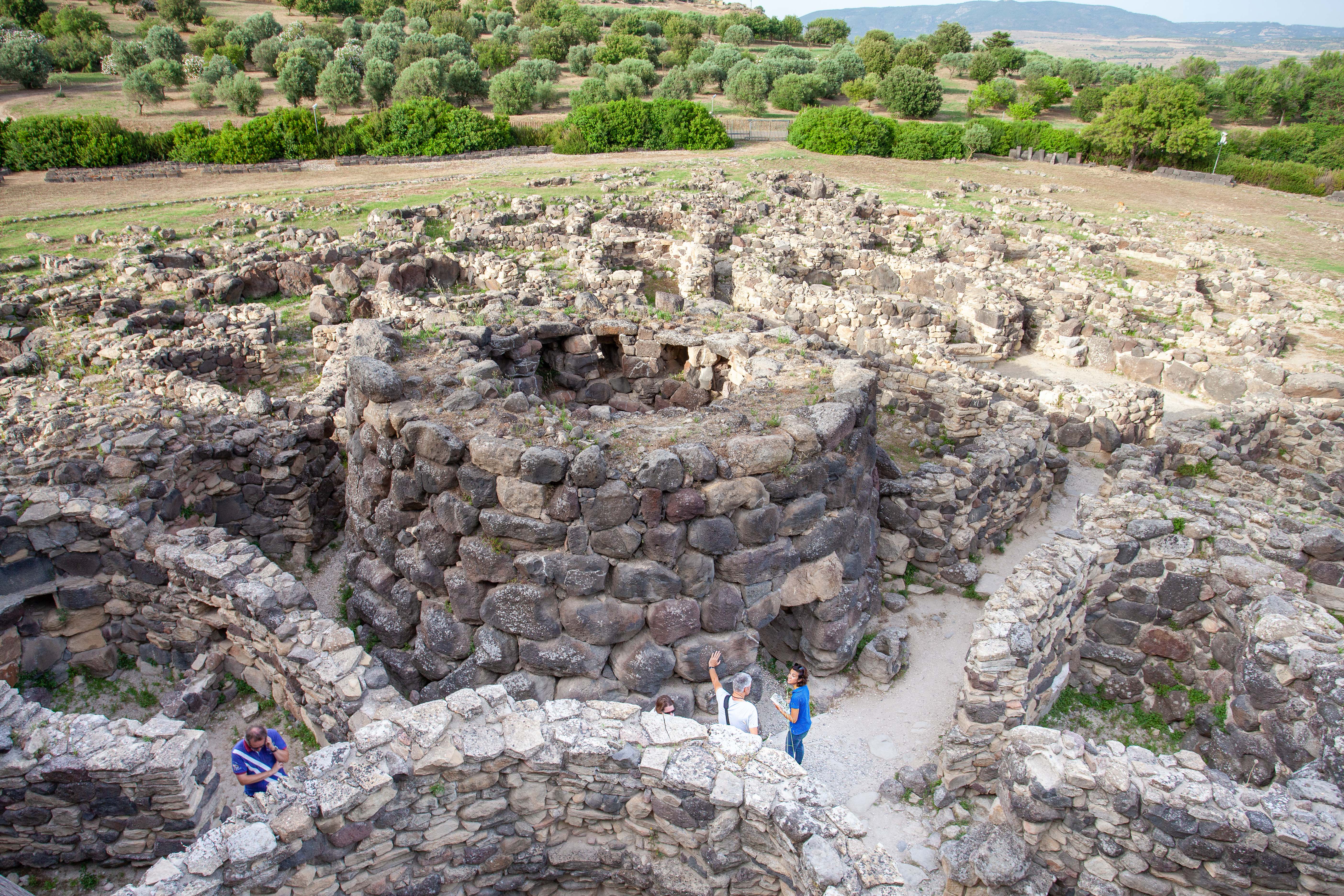 Zwischen den Steinbauten der Nuraghe "Su Nuraxi" bei Barumini wirken die Menschen klein.